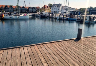Vue d’une jetée en bois sur un port de plaisance avec bateaux et maisons à Haderslev, Danemark.