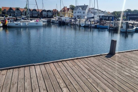 Vue d’une jetée en bois sur un port de plaisance avec bateaux et maisons à Haderslev, Danemark.