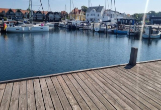 Vue d’une jetée en bois sur un port de plaisance avec bateaux et maisons à Haderslev, Danemark.