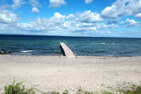 Photo d'une plage de galets et d'une jetée au bord de la mer, prise au gîte pour 4 personnes à Haderslev, Danemark.