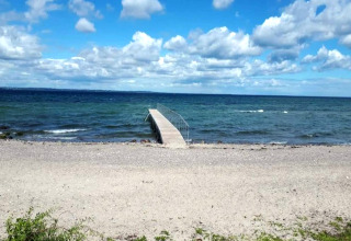 Photo d'une plage de galets et d'une jetée au bord de la mer, prise au gîte pour 4 personnes à Haderslev, Danemark.