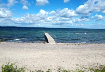 Photo d'une plage de galets et d'une jetée au bord de la mer, prise au gîte pour 4 personnes à Haderslev, Danemark.