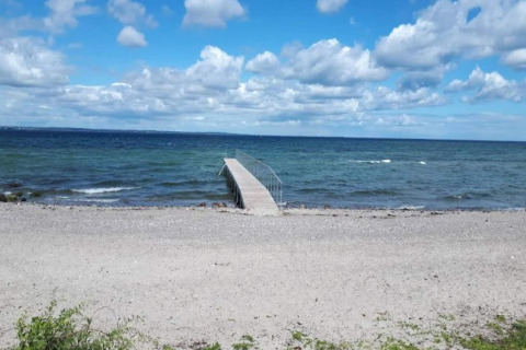 Photo d'une plage de galets et d'une jetée au bord de la mer, prise au gîte pour 4 personnes à Haderslev, Danemark.