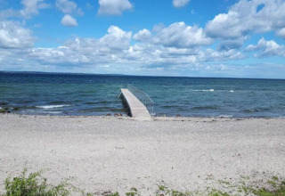 Photo d'une plage de galets et d'une jetée au bord de la mer, prise au gîte pour 4 personnes à Haderslev, Danemark.