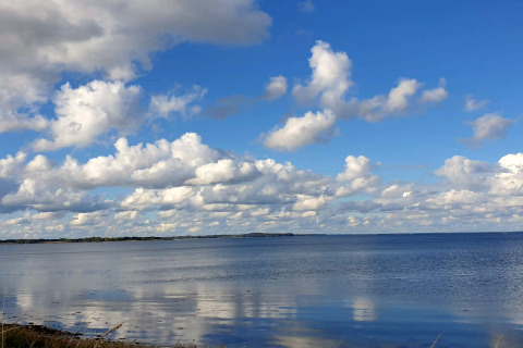 Vue sur la mer et le ciel nuageux depuis une maison de vacances à Haderslev, Danemark, lors d’une journée ensoleillée.