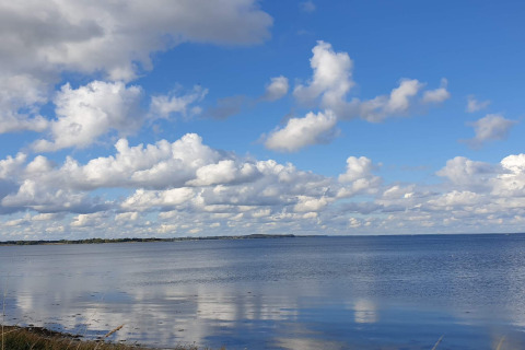 Vue sur la mer et le ciel nuageux depuis une maison de vacances à Haderslev, Danemark, lors d’une journée ensoleillée.
