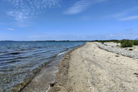 Vue sur la côte près du «4 person holiday home in Haderslev» avec plage de sable et ciel bleu au Danemark.