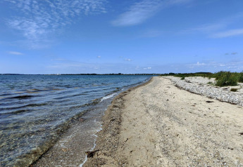 Kystudsigt ved stranden nær «4 person holiday home in Haderslev» med klart vand og blå himmel i Danmark.