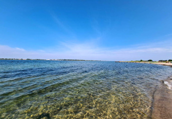 Strandudsigt fra «4 personers feriehus i Haderslev» i Danmark, klart vand og blå himmel.
