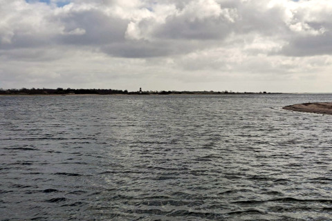 Vue sur l’eau et la côte depuis un gîte pour 4 personnes à Haderslev, Danemark, sous un ciel nuageux.
