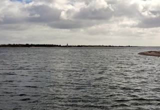 Vue sur l’eau et la côte depuis un gîte pour 4 personnes à Haderslev, Danemark, sous un ciel nuageux.