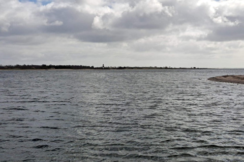 Vue sur l’eau et la côte depuis un gîte pour 4 personnes à Haderslev, Danemark, sous un ciel nuageux.
