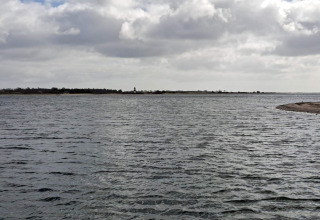 Vue sur l’eau et la côte depuis un gîte pour 4 personnes à Haderslev, Danemark, sous un ciel nuageux.