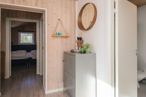 Indgangsområde i feriebolig i Glesborg, Danmark med moderne indretning, spejl og soveværelse i baggrunden.