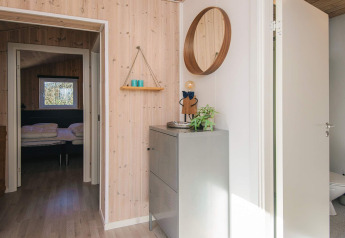 Inkomhal vakantiehuis voor 5 personen in Glesborg, Denemarken, met moderne inrichting, spiegel en zicht op slaapkamer.