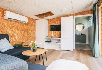 Woonkamer in vakantiehuis in Glesborg, Denemarken, met moderne inrichting, airco en zicht op badkamer.