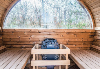 Vista interna di una sauna in legno con finestra panoramica presso casa vacanze per 5 a Glesborg, Danimarca.
