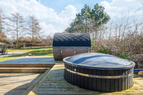 Udendørs spa og sauna på terrasse ved feriehus til 5 personer i Glesborg, Danmark, omgivet af natur.