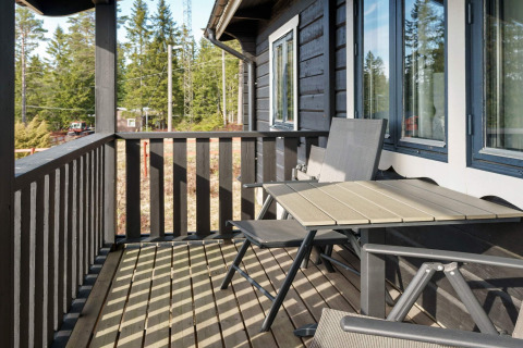 Balkon met tafel en stoelen bij een 6-persoons vakantiehuis in Kopparberg, Zweden, met uitzicht op het bos.