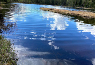 Meer met reflecties van wolken en bomen bij een 6-persoons vakantiehuis in Kopparberg, Zweden.