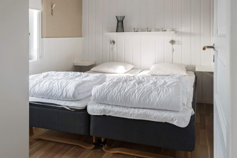 Slaapkamer met twee eenpersoonsbedden en witte wanden in een vakantiehuis in Kopparberg, Zweden.