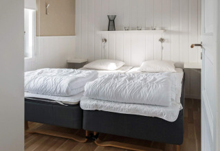 Slaapkamer met twee eenpersoonsbedden en witte wanden in een vakantiehuis in Kopparberg, Zweden.