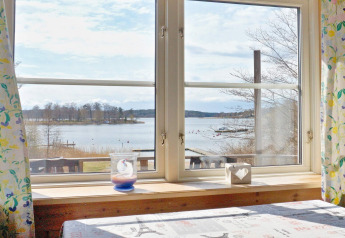 Vista desde una ventana en la casa de vacaciones para 6 personas en VAXHOLM, Suecia, con lago y naturaleza.