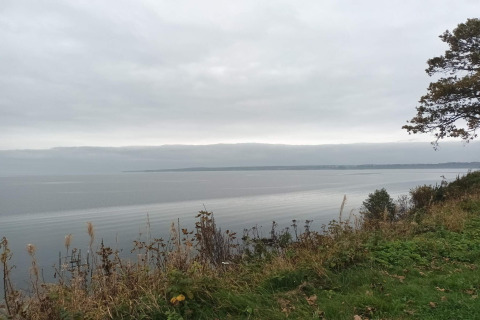 Uitzicht over het water vanaf een heuvel bij het 6-persoons vakantiehuis in Børkop, Denemarken, onder een bewolkte lucht.