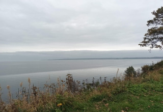 Uitzicht over het water vanaf een heuvel bij het 6-persoons vakantiehuis in Børkop, Denemarken, onder een bewolkte lucht.