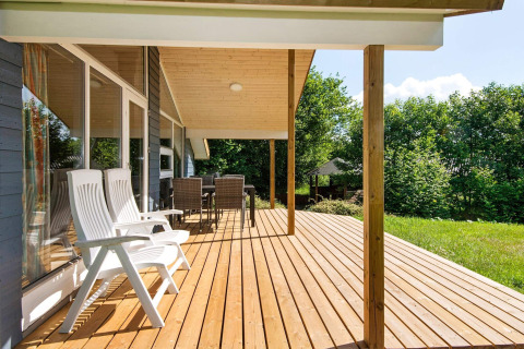 Zonnig houten terras met witte stoelen bij het 6-persoons vakantiehuis in Børkop, Denemarken.