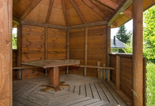 Houten paviljoen met banken en tafel bij het 6-persoons vakantiehuis in Børkop, Denemarken.