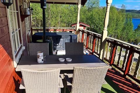 Terras van het chalet '7 person holiday home in JARFJORD', met eettafel en zicht op het meer.