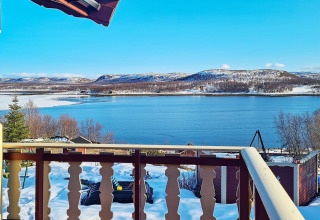 Schitterend uitzicht op meer en sneeuwlandschap vanaf balkon van 7-persoons huisje in Jarfjord, Zweden.