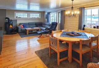 Soggiorno nello chalet '7 person holiday home in JARFJORD' in Svezia con camino, divano e tavolo da pranzo.