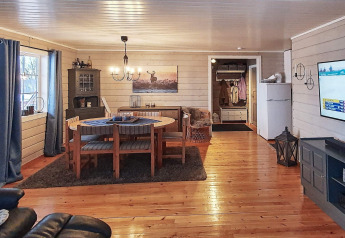 Acogedora sala de chalet con comedor, suelo de madera y ventanas grandes para 7 personas en Suecia.