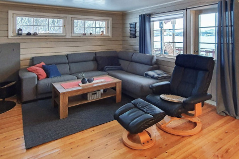 Gemütliches Wohnzimmer im Ferienhaus in Jarfjord, Schweden, mit Sofa, Sessel und Seeblick.