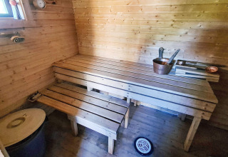 Interieur van een traditionele sauna met houten banken en emmers in een vakantiehuis in Jarfjord, Zweden.