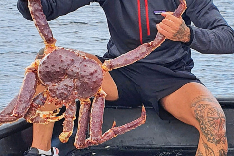 Een persoon houdt een grote koningskrab vast op een boot bij het water bij '7 person holiday home in Jarfjord', Zweden.