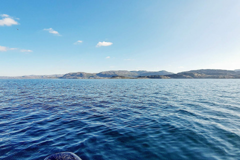 Zicht op zee en bergen vanuit een vakantiehuis voor 7 personen in Jarfjord, Zweden op een zonnige dag.