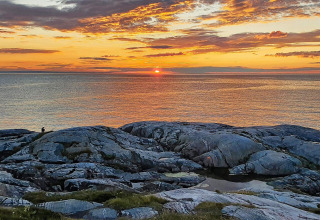 Atardecer sobre el mar visto desde las rocas cerca de una casa vacacional para 7 personas en Jarfjord, Suecia.