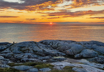 Sunset over the sea viewed from rocky cliffs near a 7-person holiday home in Jarfjord, Sweden.