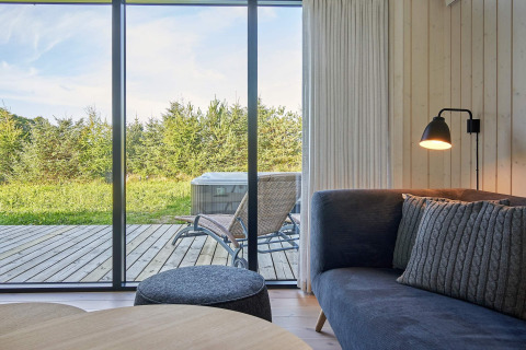 Uitzicht vanuit woonkamer in 8-persoons vakantiehuis in Aakirkeby, Denemarken, met terras en stoelen.