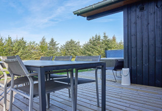 Terraza exterior en casa de vacaciones para 8 personas en Aakirkeby, Dinamarca con mesa, sillas y jacuzzi