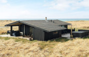 7 person holiday home in Hjørring, Denmark, with terrace and sea view, surrounded by grassy dunes.