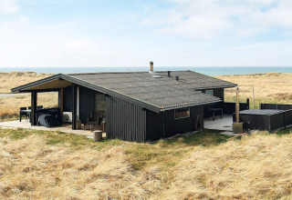 Casa vacanze per 7 persone a Hjørring, Danimarca, immersa tra dune erbose con vista sul mare.