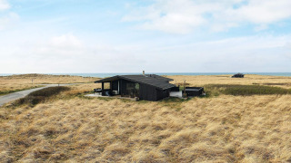 Vakantiehuis voor 7 personen in Hjørring, omgeven door droge grasvelden en zicht op de zee.