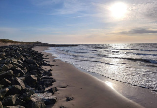 Costa rocciosa e onde al tramonto vicino a Hjørring, Danimarca, vista da una casa vacanze per 7 persone.