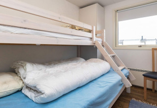 Lichte kamer met stapelbedden, ladder, stoel en raam in 7-persoons vakantiewoning in Hjørring, Denemarken.