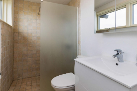 Modern bathroom at a Hjørring holiday home featuring a shower, white sink, large mirror, and windows.