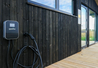 Stazione di ricarica per auto elettrica sul muro in legno al lodge 7 person holiday home a Hjørring, Danimarca.